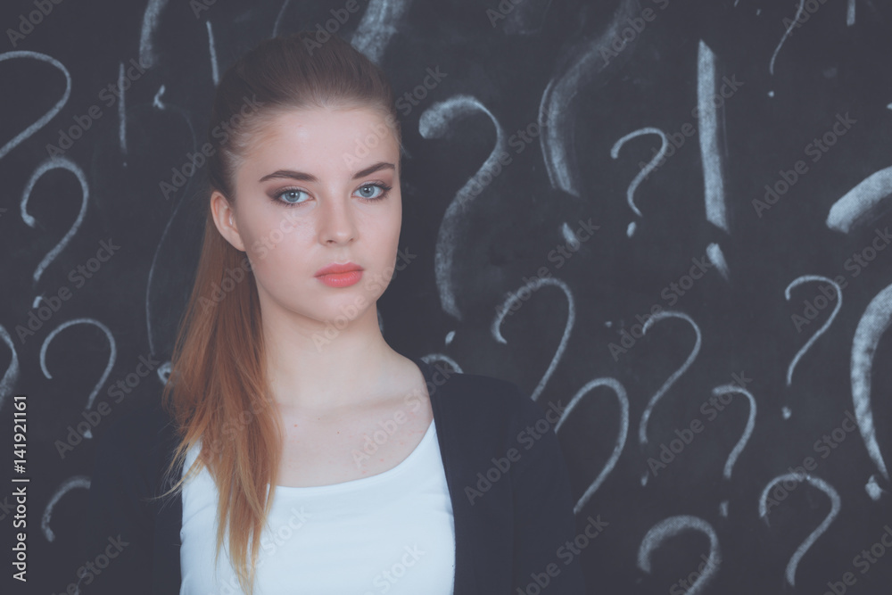 Young girl with question mark on a gray background Young girl with question mark on a gray background