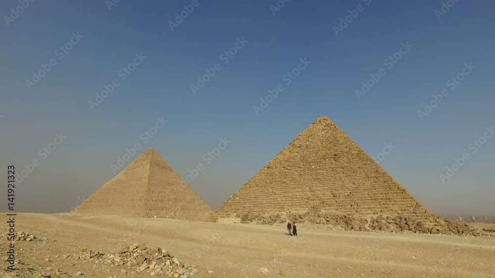 CAIRO, EGYPT - FEBRUARY 14, 2016:Tourists walking in front of Giza pyramids CAIRO, EGYPT - FEBRUARY 14, 2016:Tourists walking in front of Giza pyramids