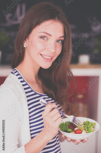 Young woman sitting near desk in the kitchen