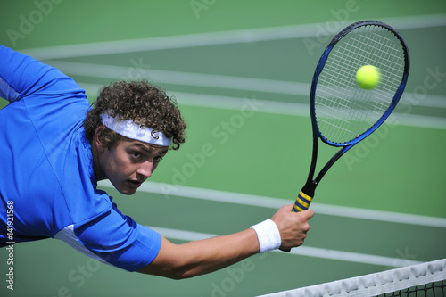 Tennis player focused on return of ball.