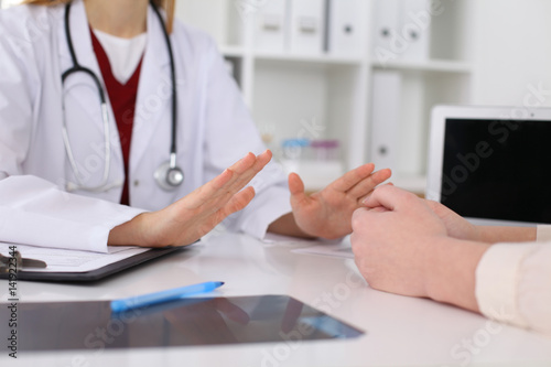 Hand of doctor  reassuring her female patient. Medical ethics and trust concept