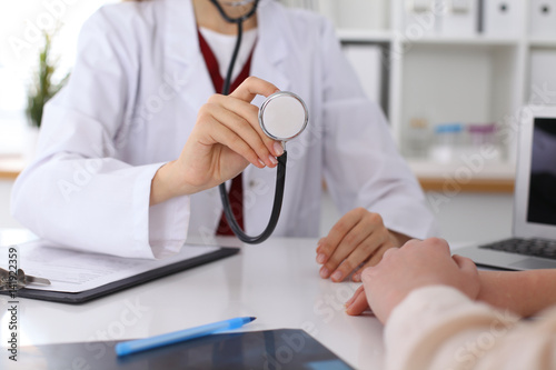 Unknown female doctor with a stethoscope in the hands. Physician is ready to examine a patient. Medicine and health care concept