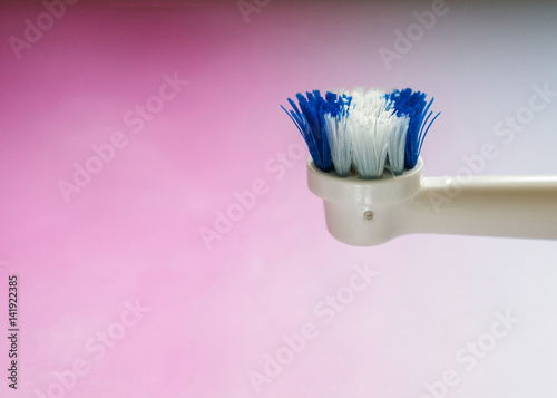 Round, worn out head of an electric toothbrush viewed from the side