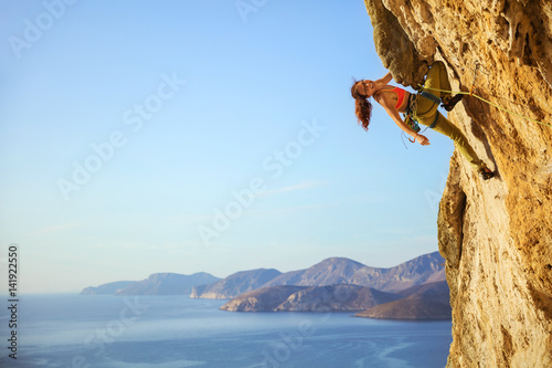 Cheerful female climber on challenging route