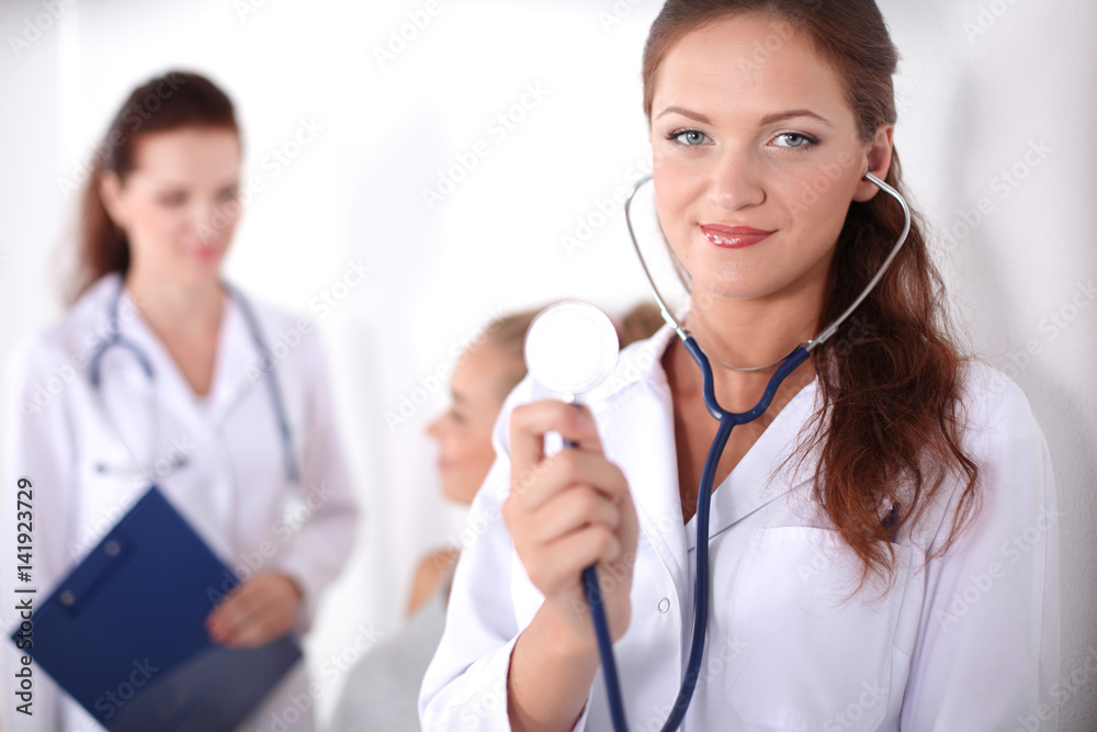 Woman doctor standing at hospital with folder Woman doctor standing at hospital with folder