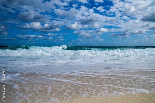 A nice tropical beach view of the ocean with clouds in the sky. New Providence  Nassau  Bahamas.