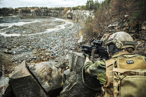 Norwegian Rapid reaction special forces FSK soldier in field uniforms in ambush among the rocks guarding perimeter waiting enemy