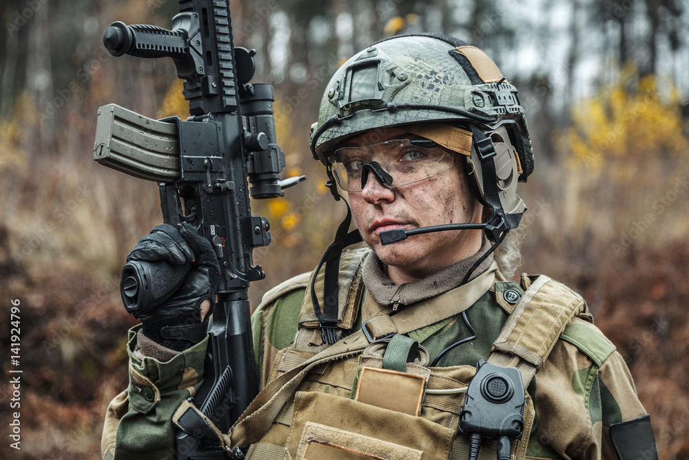 Fototapeta premium Norwegian Armed Forces Special Command FSK female soldier closeup portrait. Protective eye-wear and assault gun
