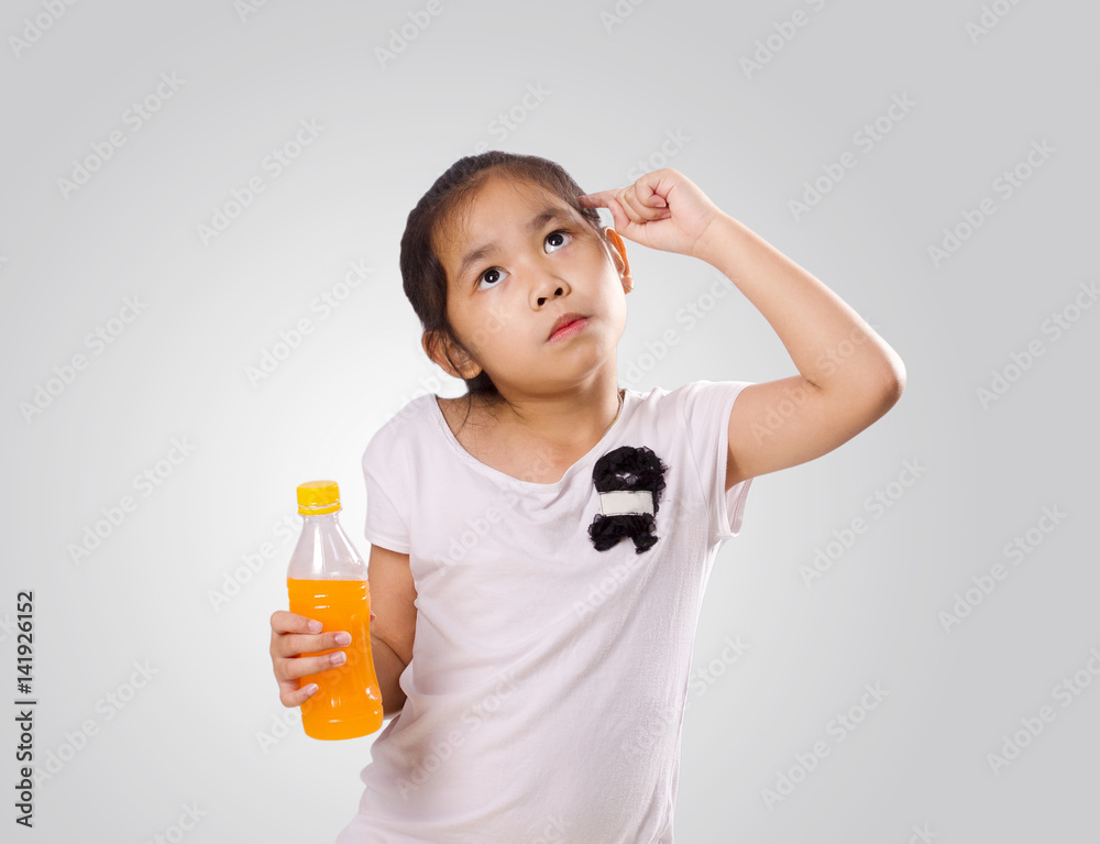 Asian little Girl Holding Plastic bottle of Orange juice in right hand and Thinking about Fruit Juice Asian little Girl Holding Plastic bottle of Orange juice in right hand and Thinking about Fruit Juice