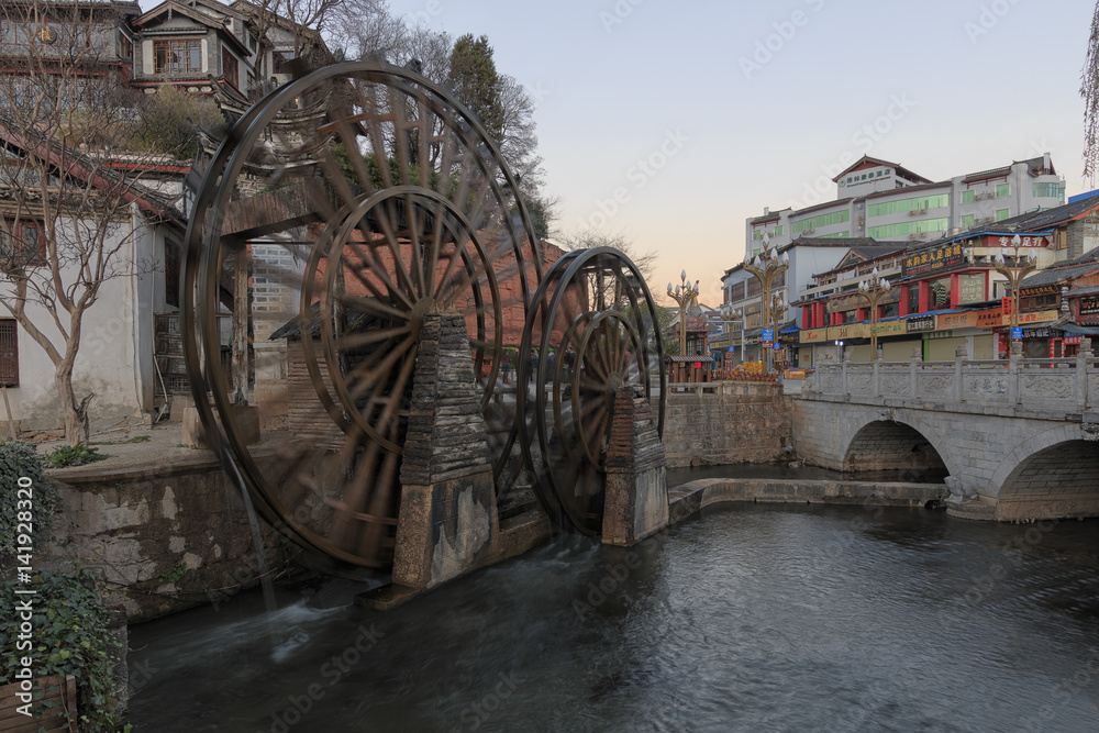 Lijiang, China - March 17, 2017: Bridge and Water wheels at the entrance on Lijiang Old Town in Yunnan