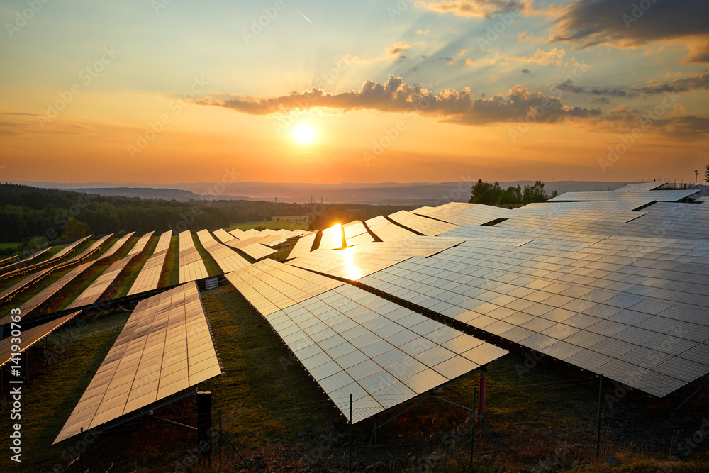 Photovoltaic panels of solar power station in the landscape at sunset. View from above.