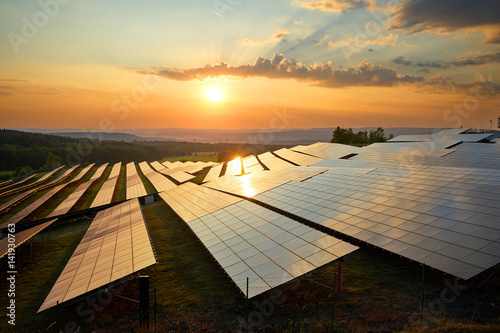 Photovoltaic panels of solar power station in the landscape at sunset. View from above. photo
