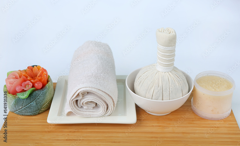 Spa herbal compressing ball with towels and Salt Scrub, Spa concept on bamboo board against white background Spa herbal compressing ball with towels and Salt Scrub, Spa concept on bamboo board against white background