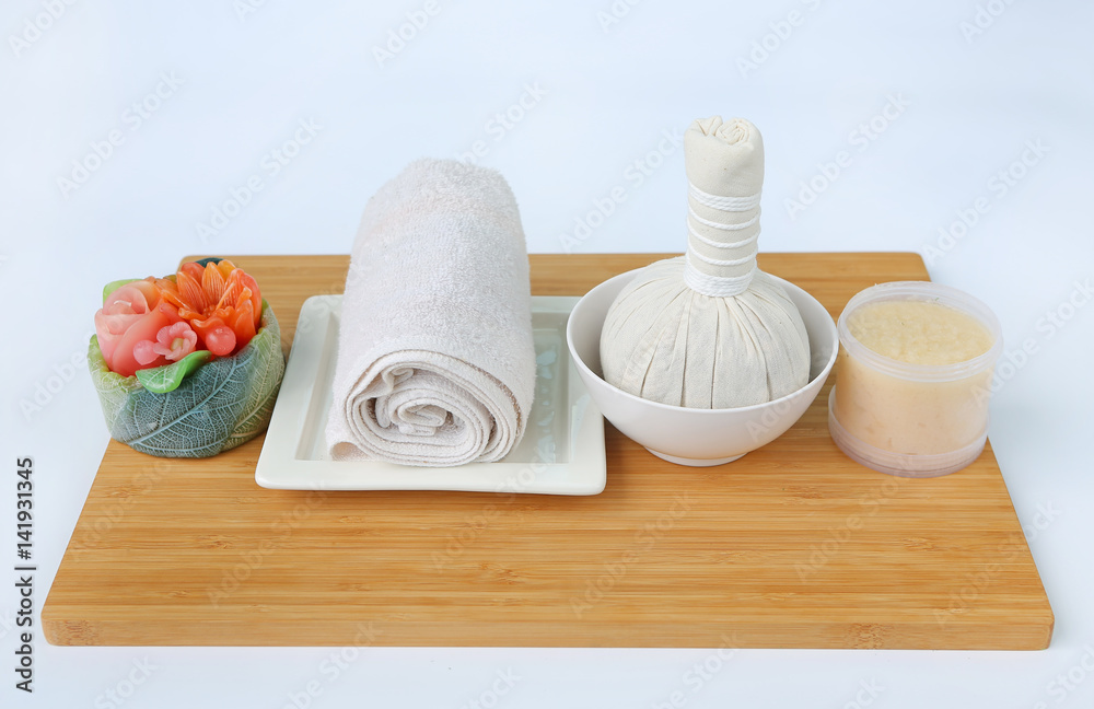 Spa herbal compressing ball with towels and Salt Scrub, Spa concept on bamboo board against white background Spa herbal compressing ball with towels and Salt Scrub, Spa concept on bamboo board against white background