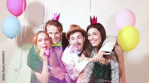 Group of funny crazy friends having great time in party photo booth, graded