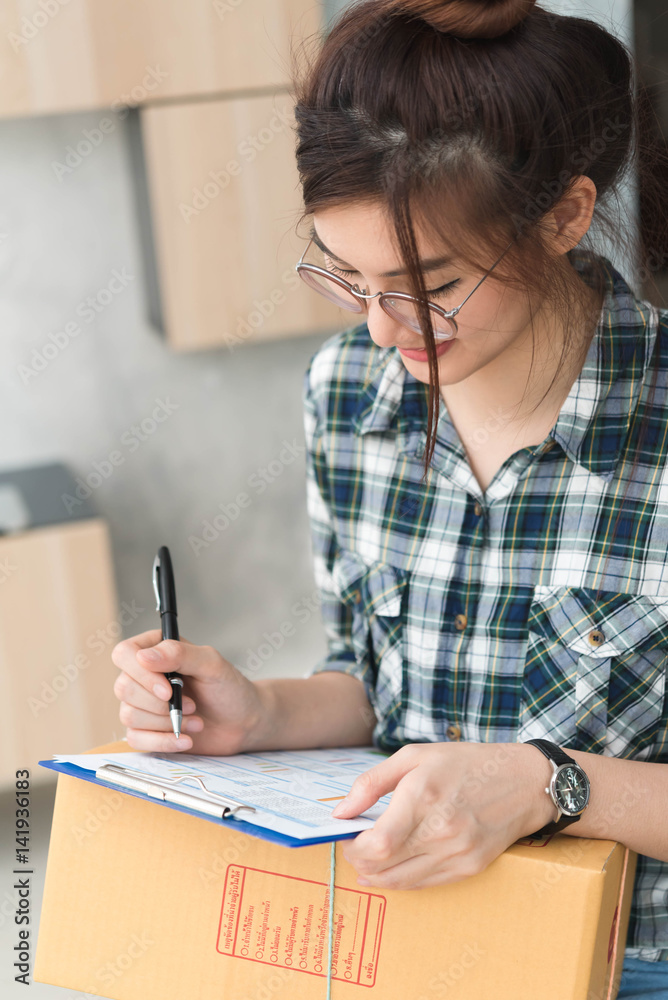 Beautyful teenager business owner work at home, alpha generation life style, prepare pacel box of product for deliver to customer Beautyful teenager business owner work at home, alpha generation life style, prepare pacel box of product for deliver to customer