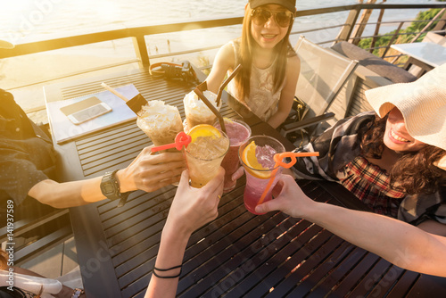 Group of woman hang out together toasting non-alcohol drink at sunset