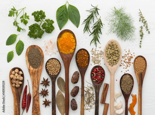 Fototapeta Naklejka Na Ścianę i Meble -  various kinds of spices and herbs with wood spoon on white background.
