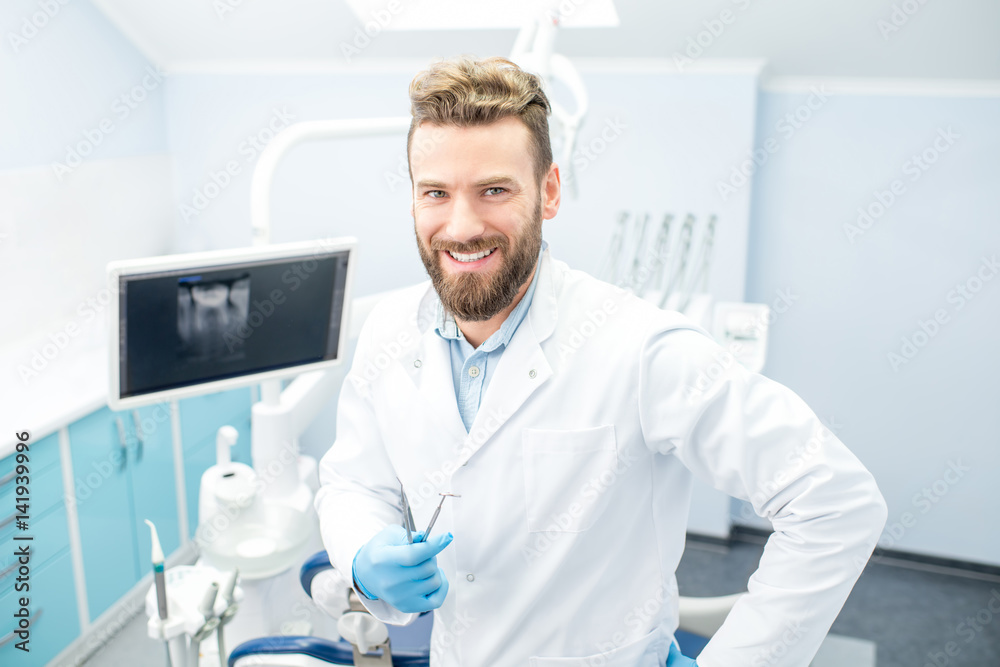Portrait of handsome dentist in uniform at the dental office Portrait of handsome dentist in uniform at the dental office