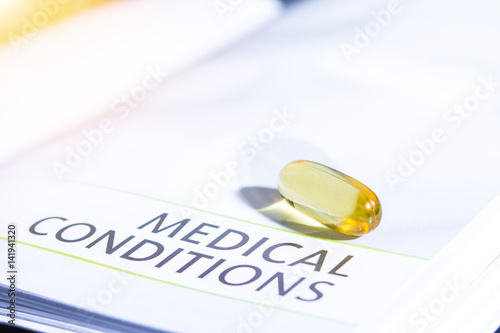 pills color yellow on the medication book concept healthcare dark tone and flare