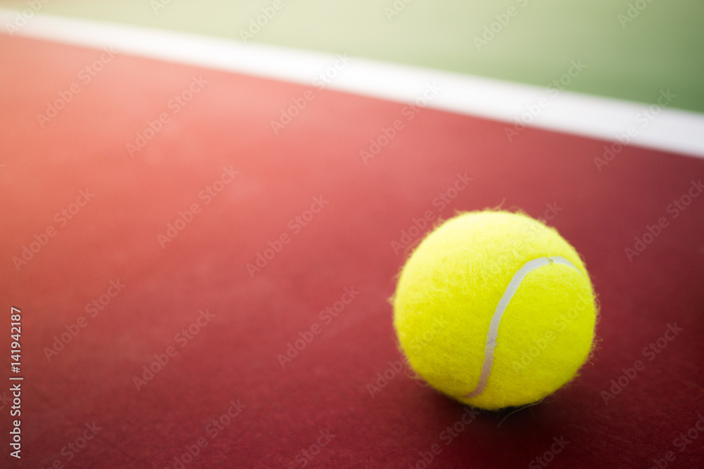 one tennis ball on green and red hard court