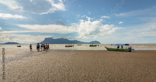 People walking on the beach to get to the boats to return from Bako National Park in Borneo photo