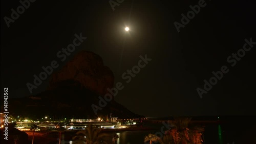 Rise of the moon over the mountain Penyal d'Ifach. Calpe. Spain. A rare event. The moon rises just above the top of the mountain Ifach. Time lapse.