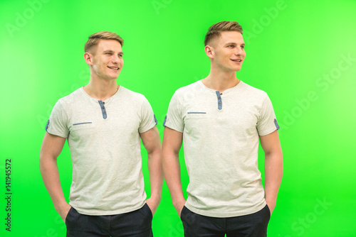 The two attractive twin stand on the green background
