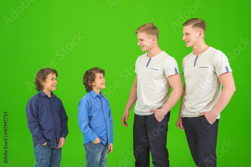 The four attractive brothers stand on the green background