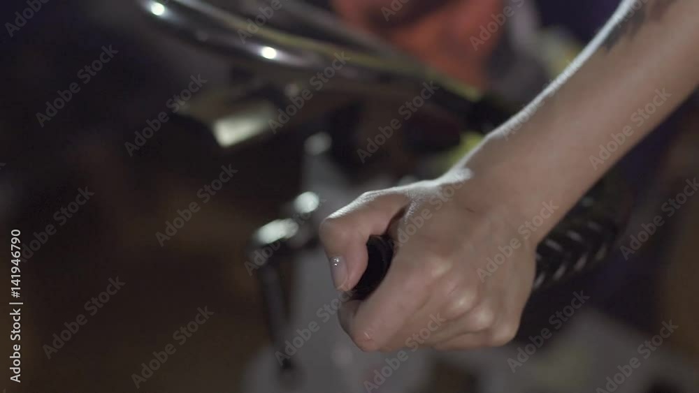 Close-up of hands of a woman holding the handles of stationary bike Close-up of hands of a woman holding the handles of stationary bike