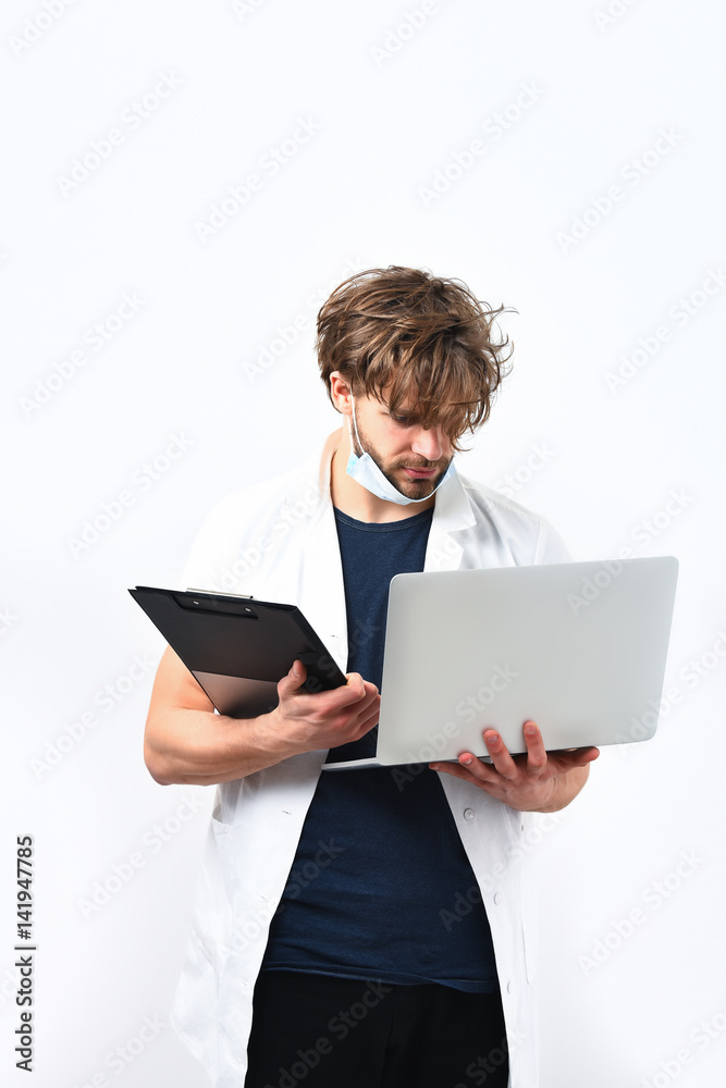 Bearded caucasian doctor or postgraduate student with laptop and clipboard