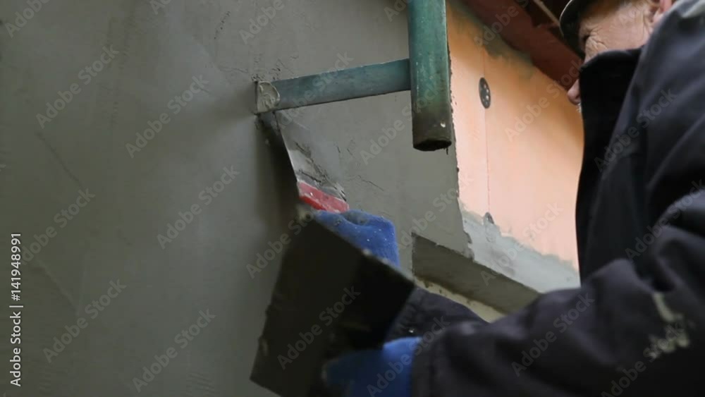 Worker plastering the facade of the building, close-up Worker plastering the facade of the building, close-up