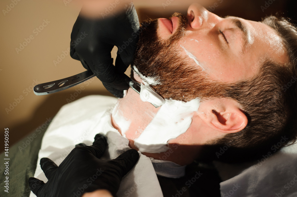 Master cuts hair and beard of men in the barbershop Master cuts hair and beard of men in the barbershop