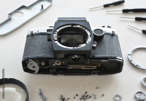 Details of the old manual lens in the frame, free space. Laid lens disassembled in a circle on a white background. Technical background. Service center photo