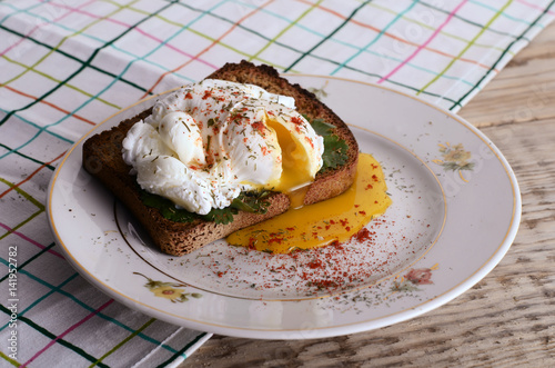 eggs pashot on a toast on a wooden table photo