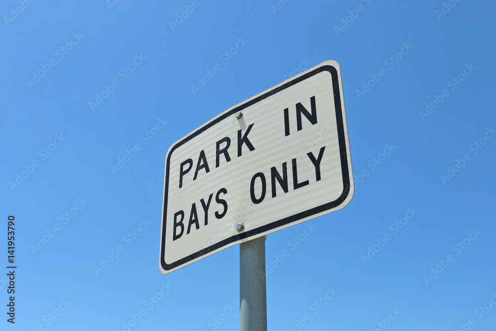 black and white Park in Bays Only sign in blue sky background black and white Park in Bays Only sign in blue sky background