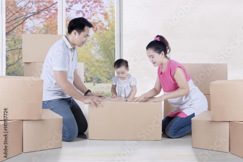 Family is packing cardboard box at home © Creativa Images