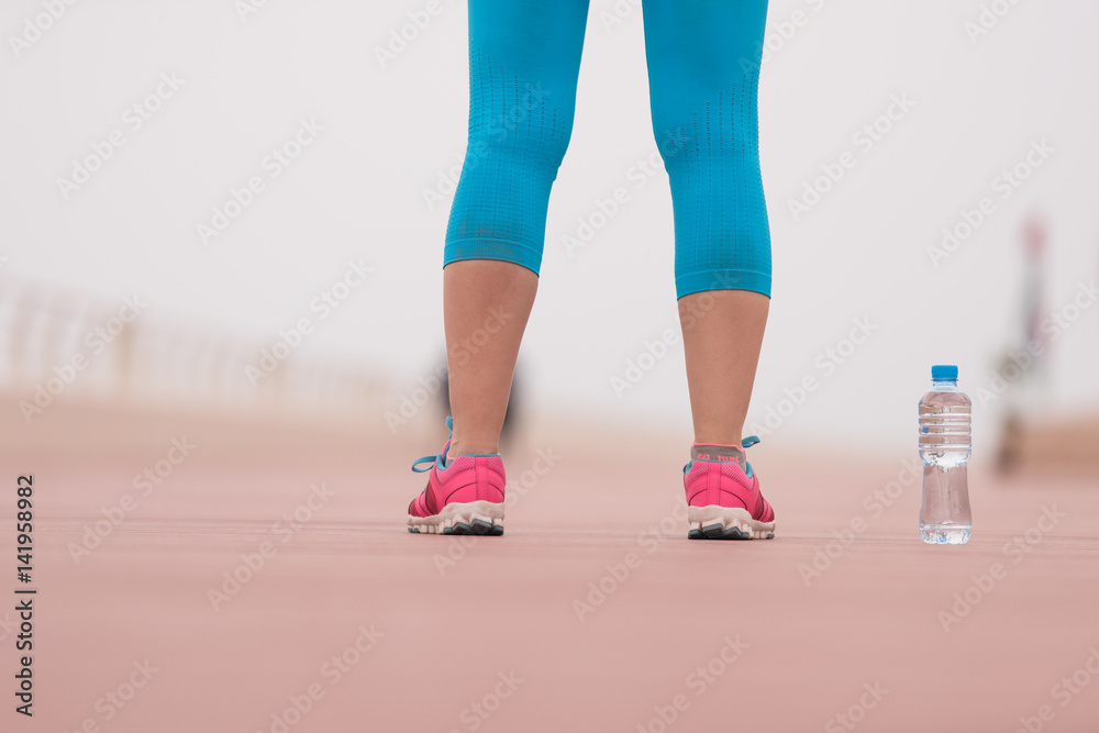 close up on running shoes and bottle of water