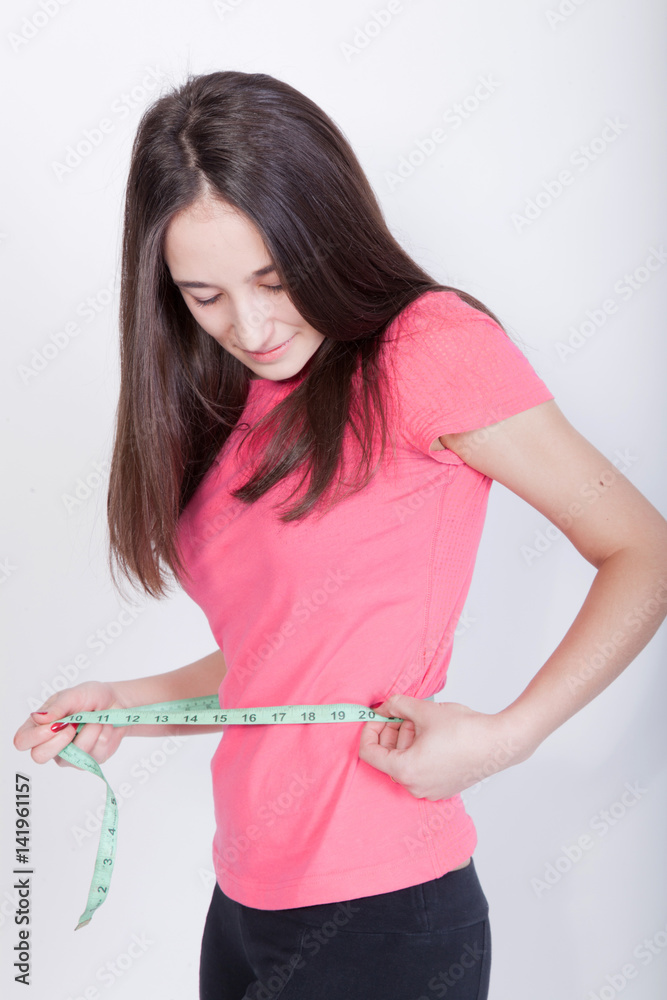 Athletic woman measures her waist Athletic woman measures her waist