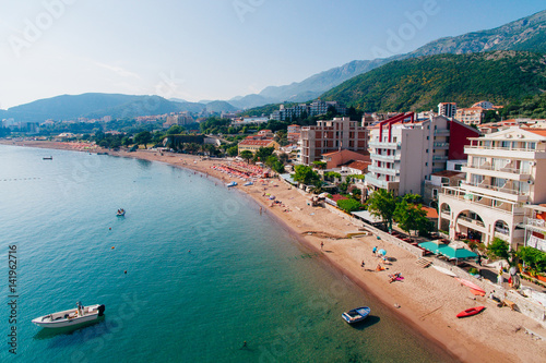 Settlement Rafailovici, Budva Riviera, Montenegro. The coast of the city on the Adriatic Sea. Aerial photography. Boats at sea, hotels, villas and apartments on the coast.