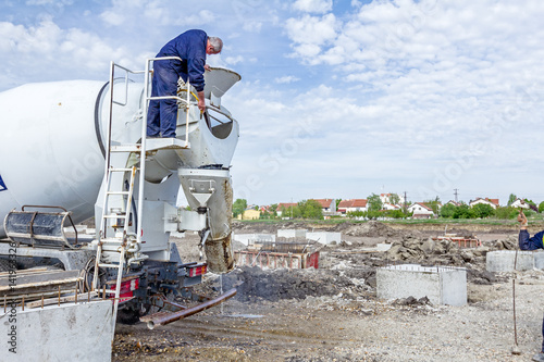 Worker is washing concrete mixer photo