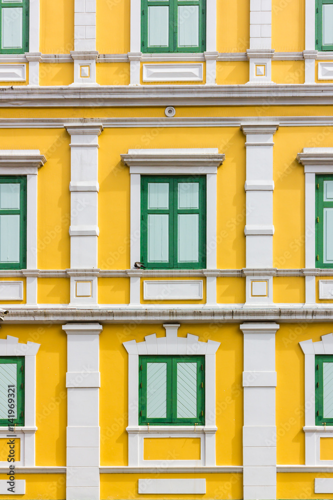 green window on yellow wall