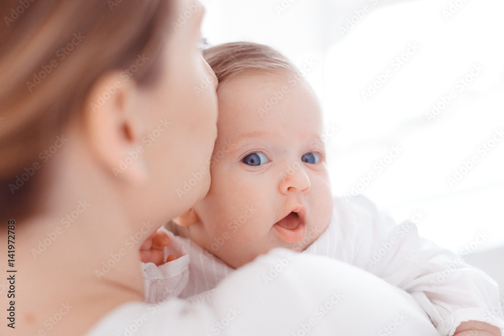 Young mother and newborn baby in white bedroom Young mother and newborn baby in white bedroom