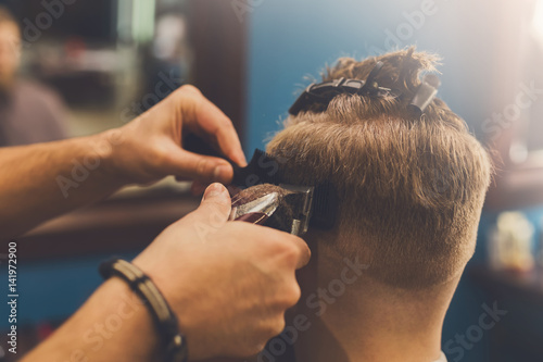 Man getting haircut by hairstylist at barbershop