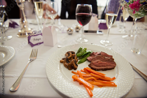 Main course menu with beef, carrots, beans and mushrooms freshly served on a white plate.