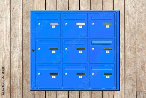 boîtes aux lettres bleues incrustées dans panneau de bois © Unclesam