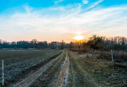 Sunrise over muddy farmland in winter