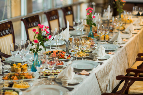 Festively decorated beautiful big table full of food ready for guests. Horizontal color photography.