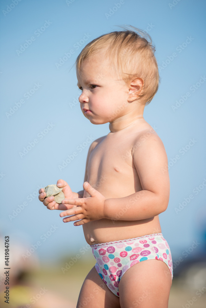 Baby playing with toys on the sandy beach near the sea. Cute little kid in sand on tropical beach. Ocean coast. Baby playing with toys on the sandy beach near the sea. Cute little kid in sand on tropical beach. Ocean coast.