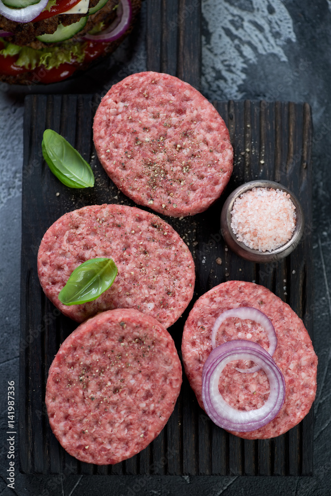 Close-up of raw burger cutlets made of ground beef meat, above view, studio shot Close-up of raw burger cutlets made of ground beef meat, above view, studio shot